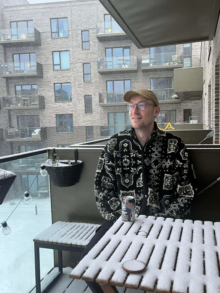 Kasper sitting on a snowy balcony